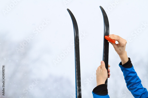 hands putting wax on skis photo