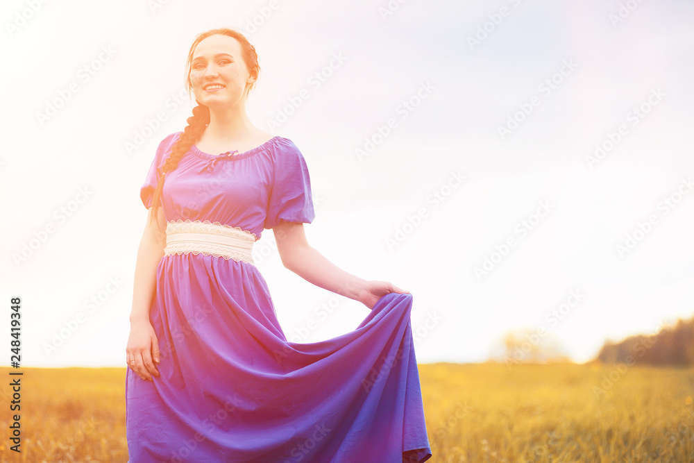 Young beautiful girl in dresses on nature. A girl in a hat walks in the park. Young woman on a picnic with a basket outside the city. Young beautiful girl in dresses on nature. A girl in a hat walks in the park. Young woman on a picnic with a basket outside the city.