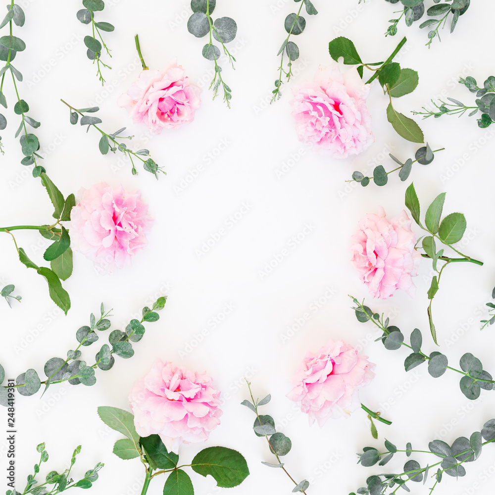 Frame of pink roses flowers and eucalyptus branches on white background. Flat lay, top view. Valentines day