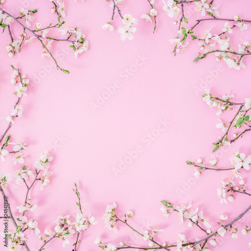 Floral frame with white flowers on pastel pink background. Flat lay, top view.
