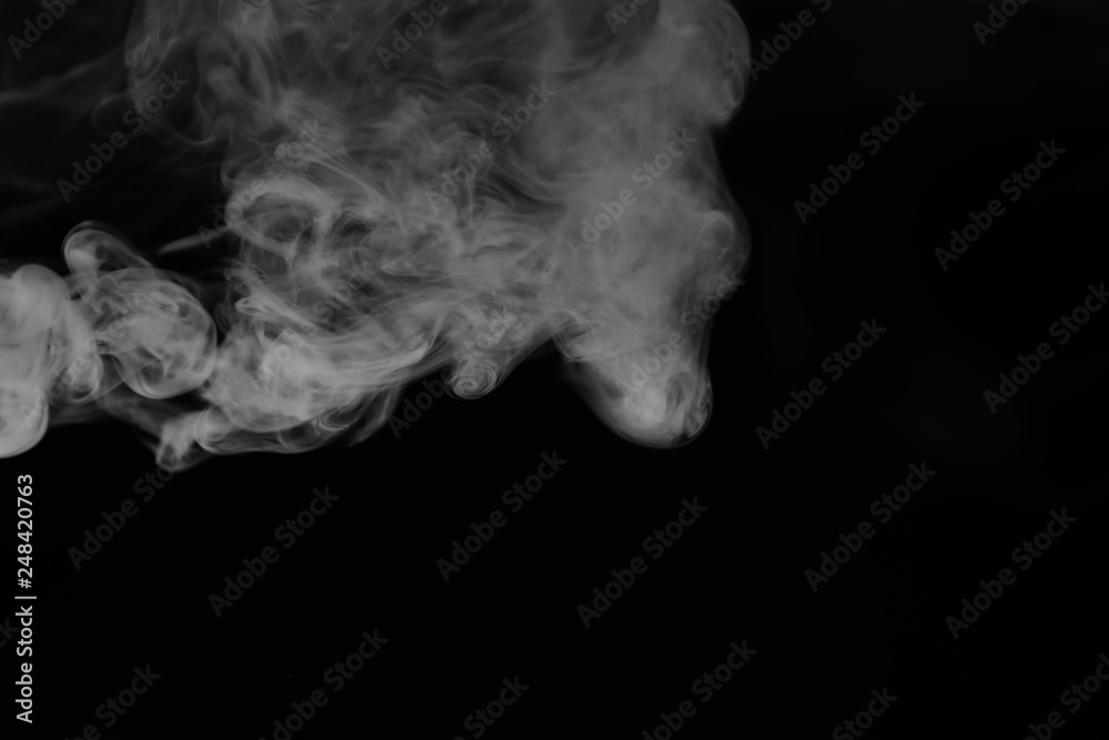 White smoke on a black background. Texture of smoke. Clubs of white smoke on a dark background for an overlay White smoke on a black background. Texture of smoke. Clubs of white smoke on a dark background for an overlay