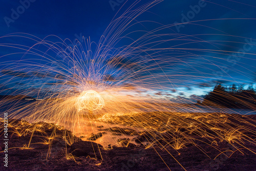 Amazing Bokeh fire dancing steel wool sea in the twilight