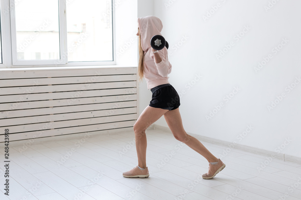 Fototapeta premium Fitness, sport and people concept - smiling sporty woman with barbell doing split squat or lunge