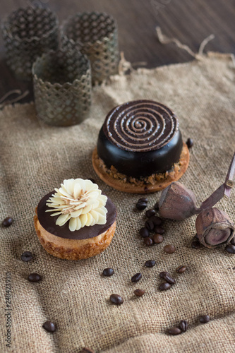 Two chocolate cakes lie on a sacking on a background of coffee.