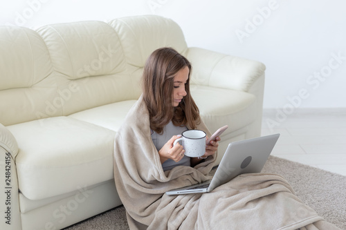 Freelance and people concept - Young woman sitting on floor and working at laptop