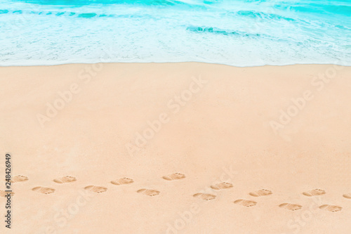 Soft wave of Blue ocean on sandy Beach with footprint. Abstract natural Background.