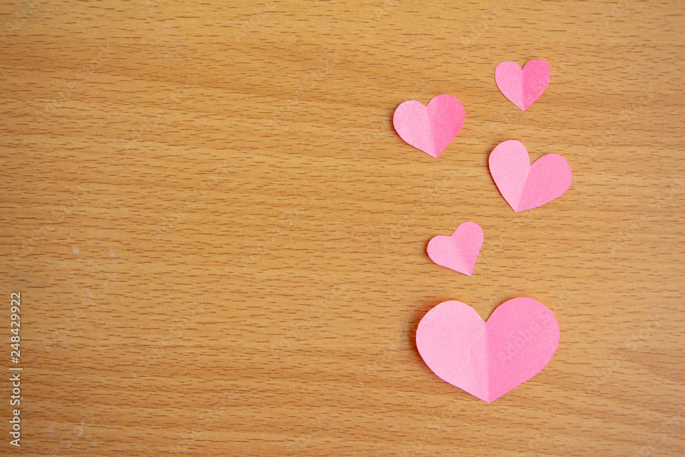 Pink paper cut of mini heart on brown wood background,love valentine concept, minimal top view flat lay. Pink paper cut of mini heart on brown wood background,love valentine concept, minimal top view flat lay.