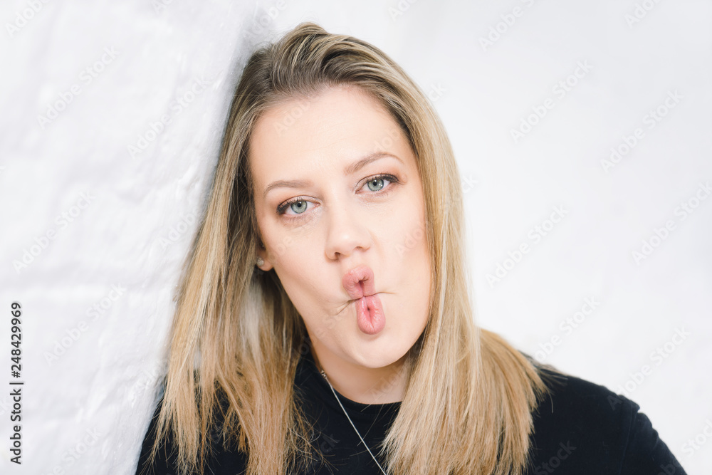 portrait of a young woman pulling a funny face with fish lips Stock Photo