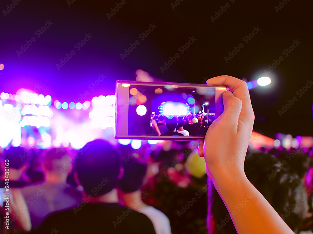 Hands of unidentified taking a photo with mobile smart phone of concert stage. Hands of unidentified taking a photo with mobile smart phone of concert stage.