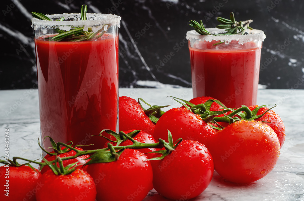 Tomato juice garnished with a rosemary branch and fresh ripe red cherry tomatoes Tomato juice garnished with a rosemary branch and fresh ripe red cherry tomatoes