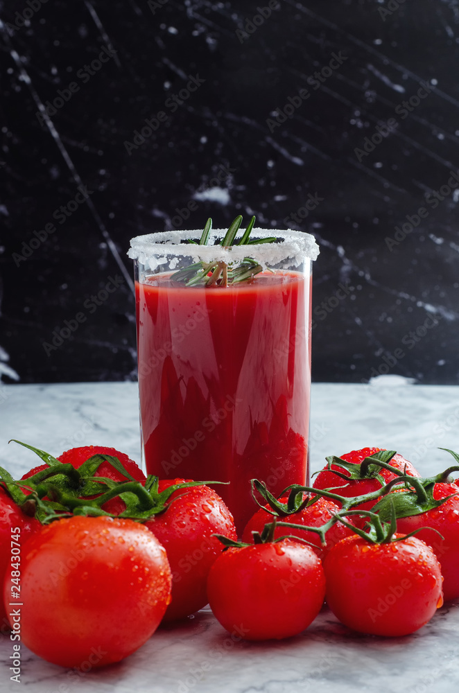 Tomato juice garnished with a rosemary branch and fresh ripe red cherry tomatoes Tomato juice garnished with a rosemary branch and fresh ripe red cherry tomatoes