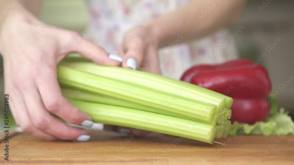 Woman in the kitchen preparing vegetables and celery, vegetarianism. Woman in the kitchen preparing vegetables and celery, vegetarianism.