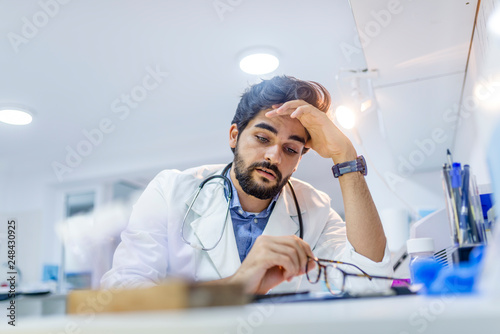 Overworked doctor in his office photo
