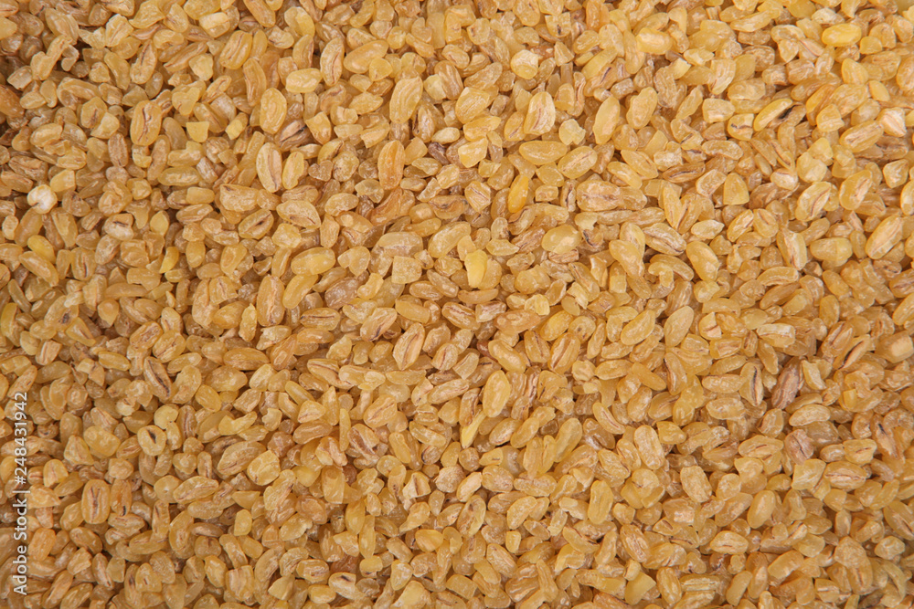 Bulgur wheat. Top view. Food Background. A scattering of bulgur wheat grains. Healthy food. Natural food.