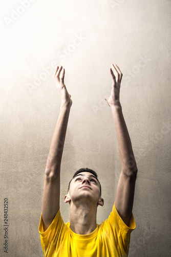 giovane uomo che allunga le mani verso l'alto photo