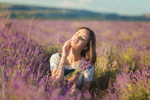 Beautiful young girl enjoying the sunlight in a lavender field