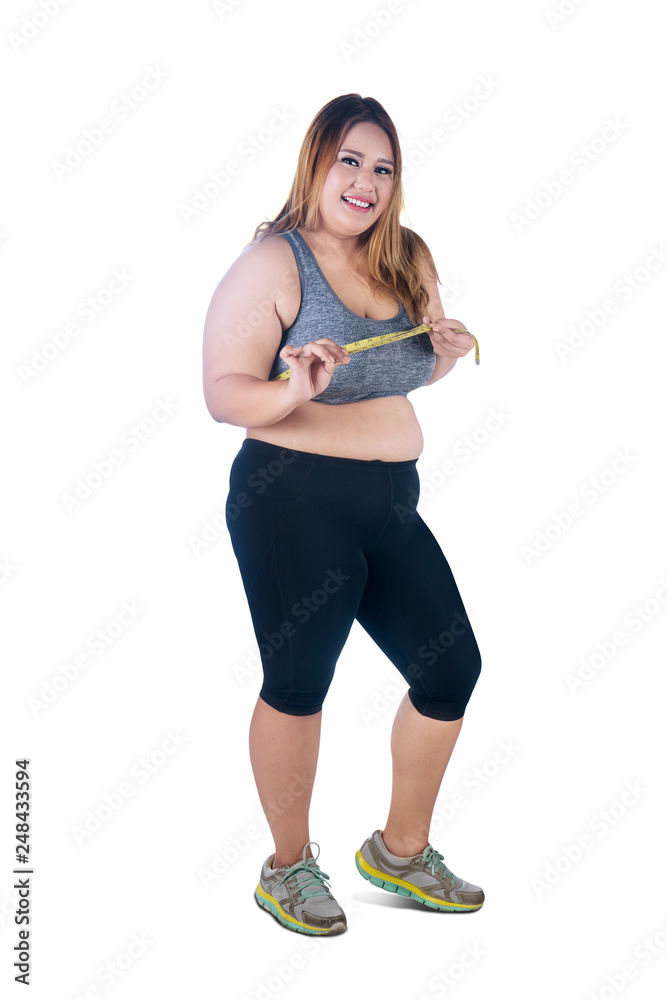 Happy obese woman measures her chest on studio Happy obese woman measures her chest on studio