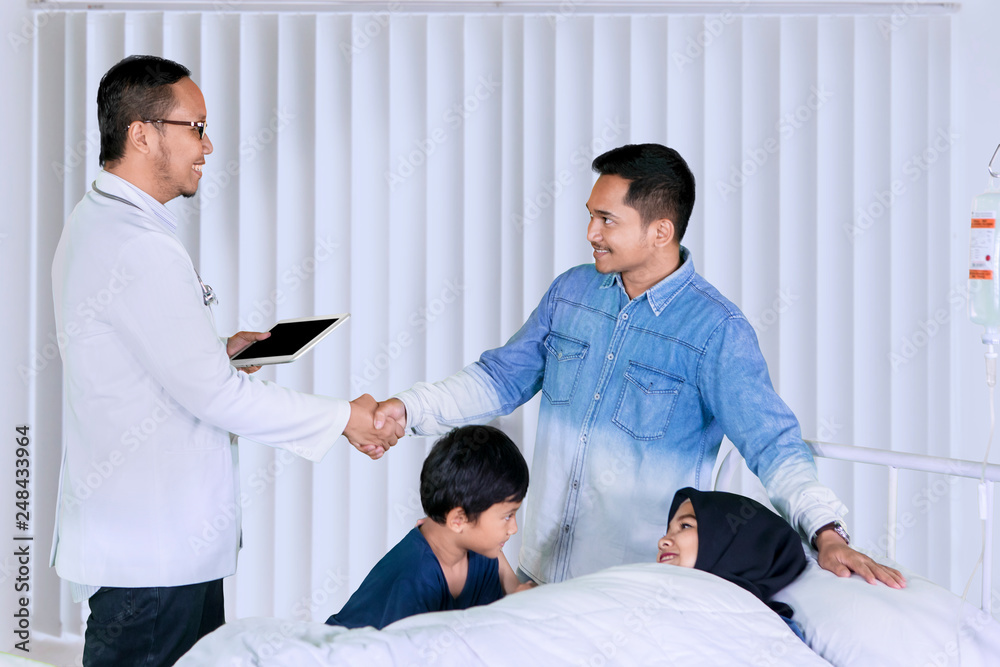 Male doctor visiting his patient family in the clinic Male doctor visiting his patient family in the clinic