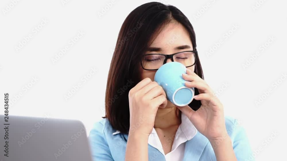 Selective focus at young Thai business woman working with computer and drink coffee from a cup.. Selective focus at young Thai business woman working with computer and drink coffee from a cup..