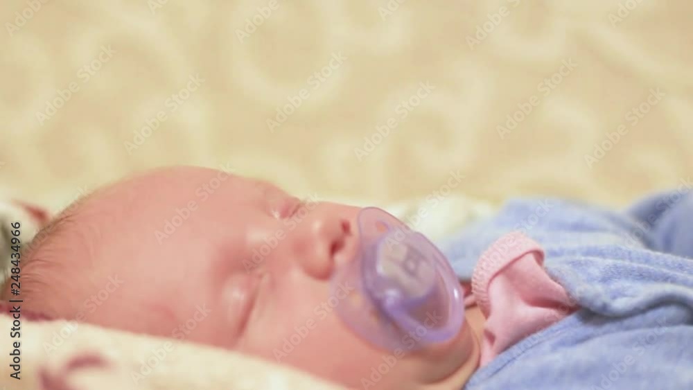 newborn baby sleeping on bed close up