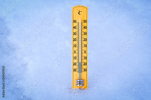 Outdoor thermometer in the snow. Thermometer display minus 15 degrees celsius