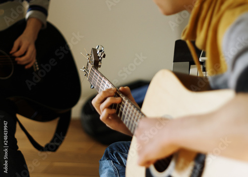 The musician plays an acoustic guitar beige, with a friend photo