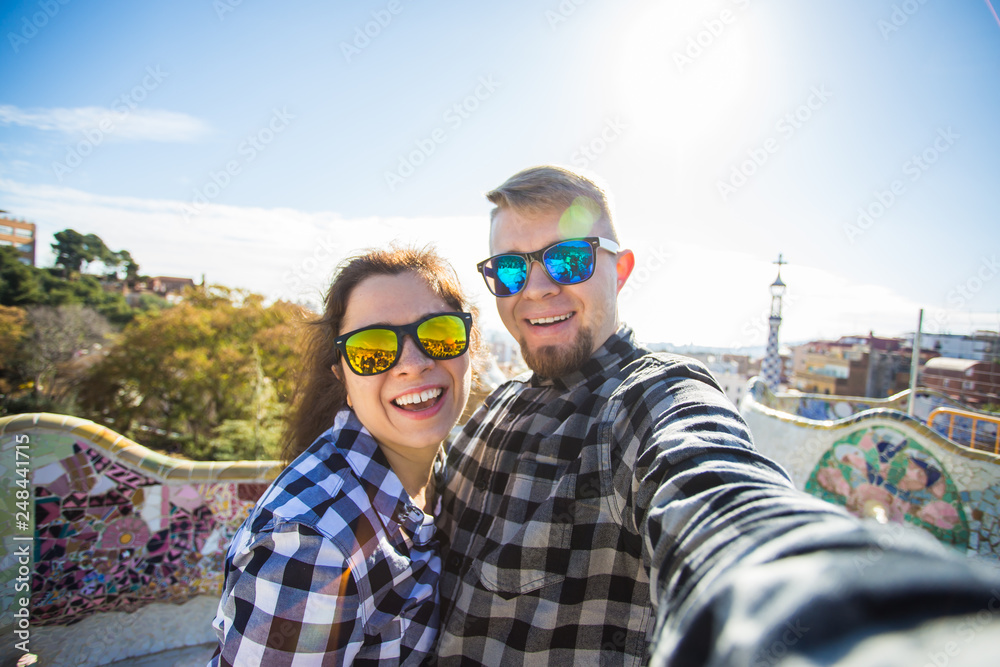 Travel couple happy making selfie portrait with smartphone in Park Guell, Barcelona, Spain. Travel couple happy making selfie portrait with smartphone in Park Guell, Barcelona, Spain.