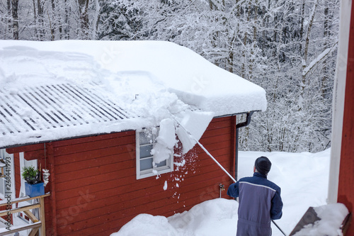  Schneeräumen auf dem Dach mit einem speziellen Schneeschieber photo