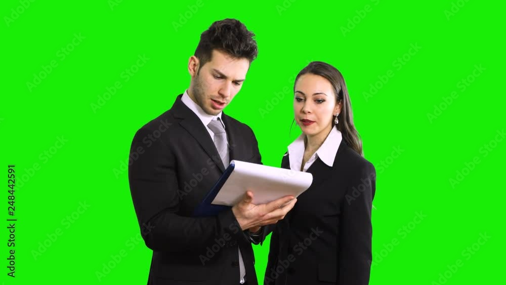 Business man and woman discussing while reading a document isolated on green screen chroma key Business man and woman discussing while reading a document isolated on green screen chroma key
