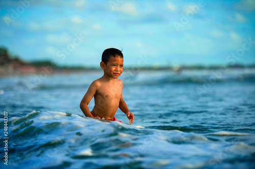5 years old cute and happy child feeling crazy free having fun on the beach playing on water and sea waves enjoying holidays excited and cheerful in travel destination