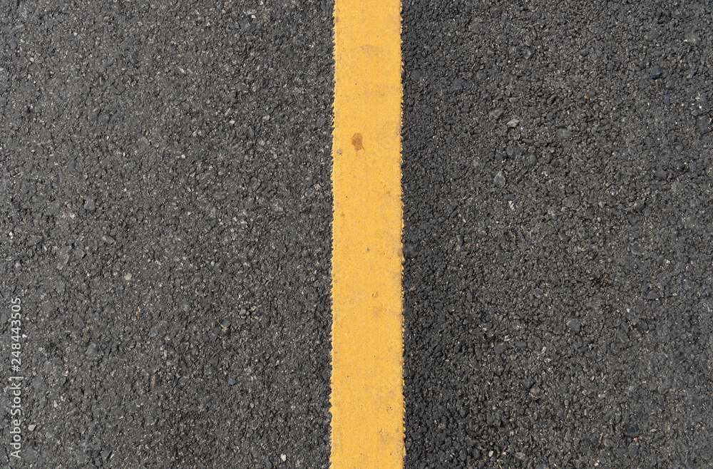 Top view surface of the asphalt road with yellow line.