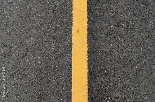 Top view surface of the asphalt road with yellow line.