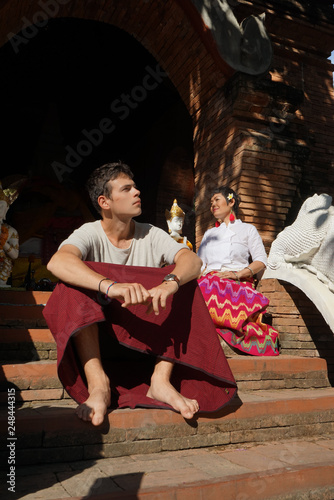 Jeune homme caucasien et femme asiatique devant un temple Thaïlande