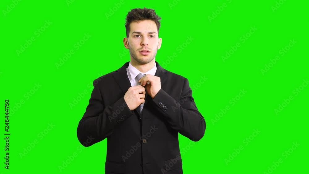 Handsome caucasian businessman adjusting his collar isolated on green screen chroma key Handsome caucasian businessman adjusting his collar isolated on green screen chroma key