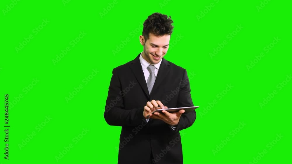 Portrait of a young businessman using a tablet computer isolated on green screen chroma key Portrait of a young businessman using a tablet computer isolated on green screen chroma key