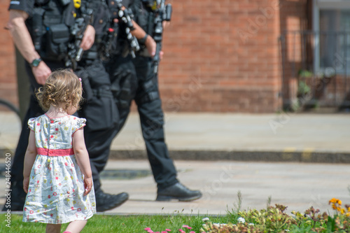 little girl walks in front of armed police patrol in tourist town respond to terrorist critical threat level