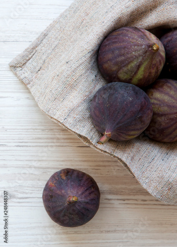 Fresh figs in a bowl on a white wooden surface, top view. Overhead, from above.