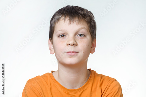 Portrait of a boy - a teenager on a white background, close-up, emotion, surprise, doubt