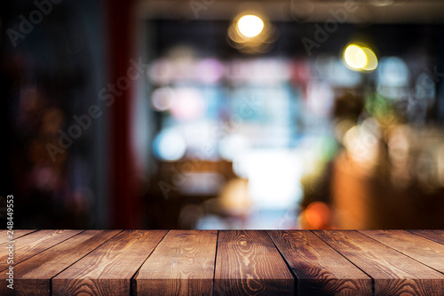wood table on blur cafe, coffee shop, bar, background - can used for display or montage your products