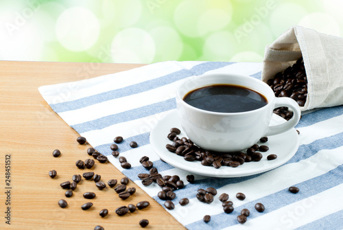 cup of coffee and beans on wooden table