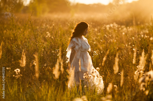 Girl walks through the meadow photo