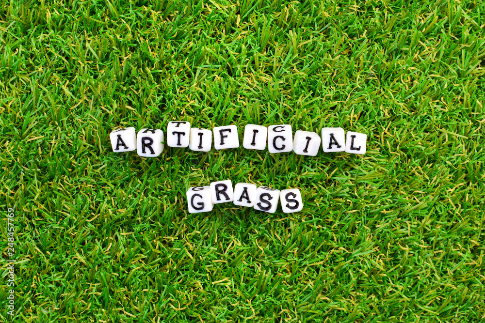 Artificial grass background and little cubes with thematic text