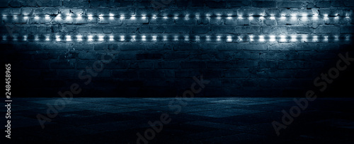 Old brick wall, dark room with brick wall, rays of searchlight light, illuminated night lights on an empty wall. Dark street, night city.