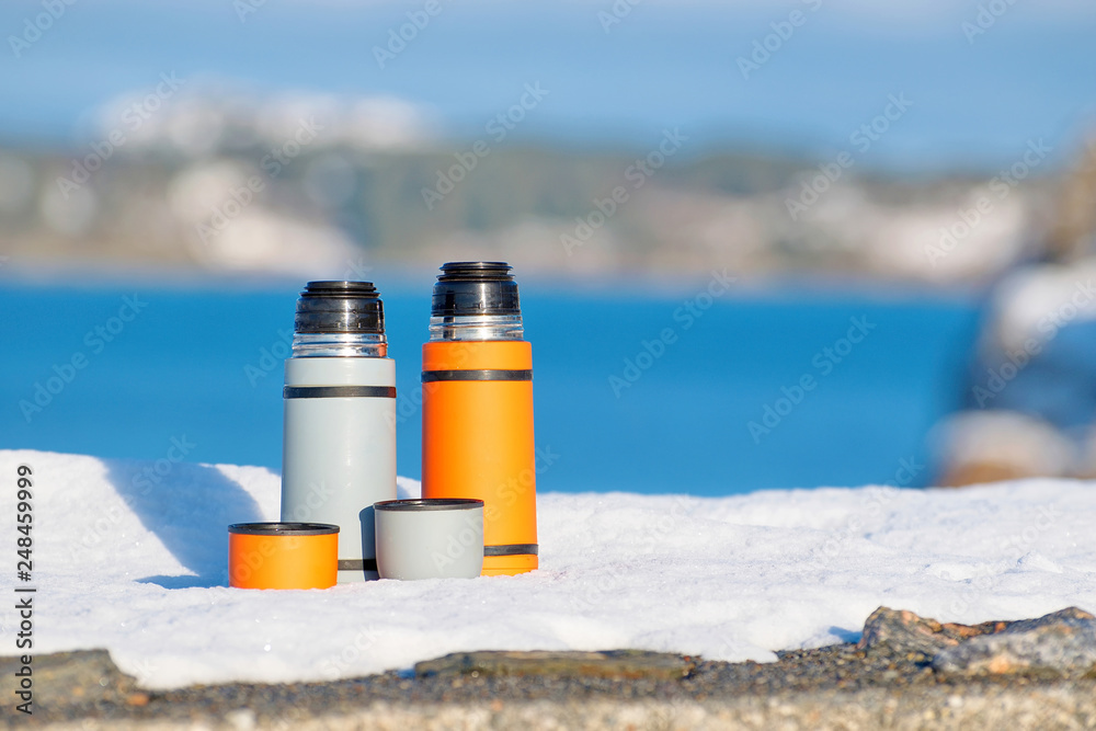 Thermos with hot tea on a snowy sea coast Thermos with hot tea on a snowy sea coast