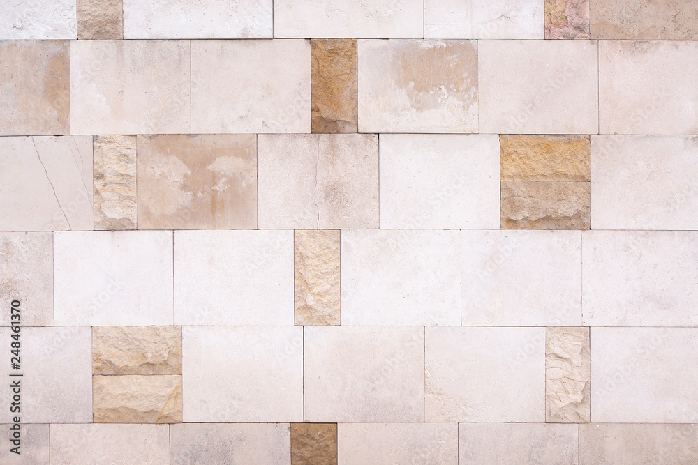 Wall Cladding Of Square And Rectangular Light Beige Smooth And Rough Stone Slabs, Mosaic Laying. Wall Cladding Of Square And Rectangular Light Beige Smooth And Rough Stone Slabs, Mosaic Laying.