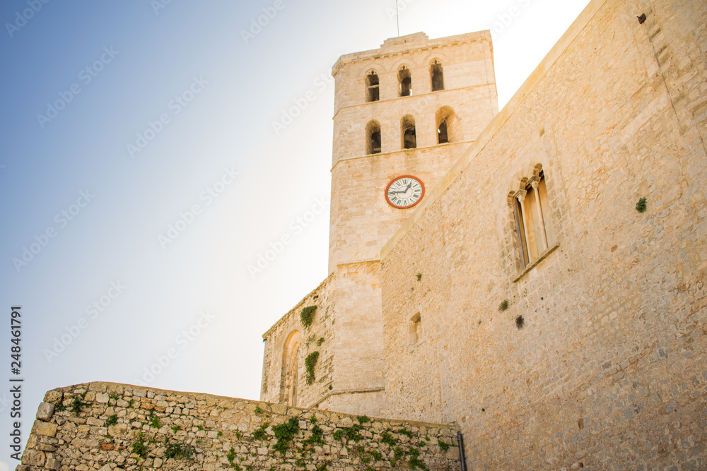 View of the Cathedral's Clock Tower of the old town of Ibiza, Spain. Architecture, travel and historical concept. 