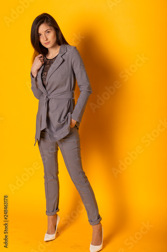 beautiful and sexy woman wearing a gray suit with a stylish women's jackets and pants. Conception of business woman, student, young business lady.