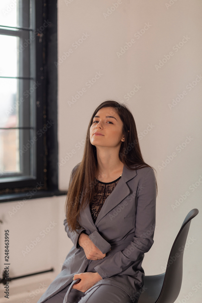 studio photo of a beautiful office woman, young company director sitting on a high chair on a white background studio photo of a beautiful office woman, young company director sitting on a high chair on a white background