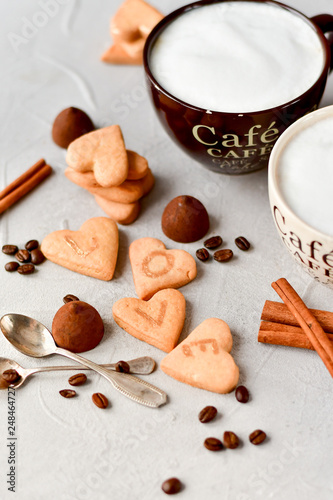 two cups of coffee and cookies in the shape of hearts, on the cookie letters LOVE. the concept of a gift for Valentine's day on February 14. selective focus