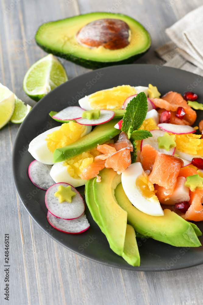 Salad with organic avocado and with salmon, eggs and radish. Decorated with mint leaf and pomegranate. Healthy lunch, vegetarian food, diet dish. food for weight loss. Selective focus and copy space Salad with organic avocado and with salmon, eggs and radish. Decorated with mint leaf and pomegranate. Healthy lunch, vegetarian food, diet dish. food for weight loss. Selective focus and copy space